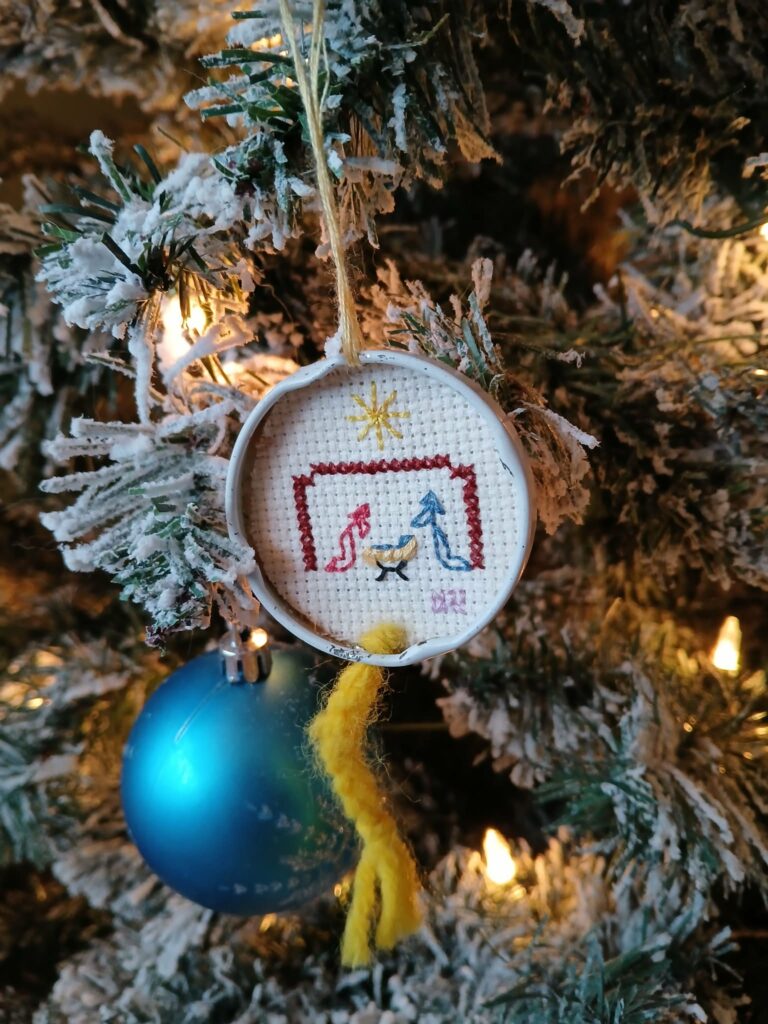 Manger scene cross stitched on a tree ornament